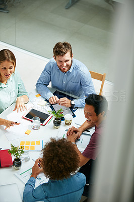 Buy stock photo High angle shot of a group of businesspeople working together around a table in an office