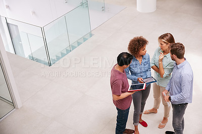 Buy stock photo High angle shot of a group of businesspeople talking together while standing in an office
