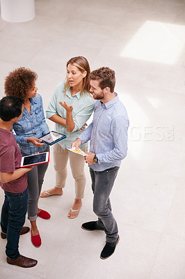 Buy stock photo High angle shot of a group of businesspeople talking together while standing in an office
