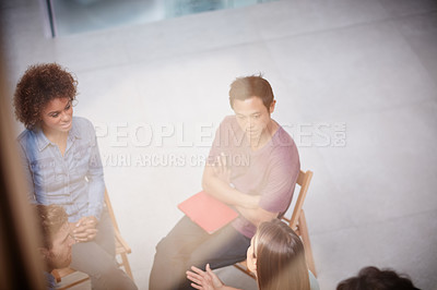 Buy stock photo High angle shot of a group of businesspeople talking together while sitting together in an office