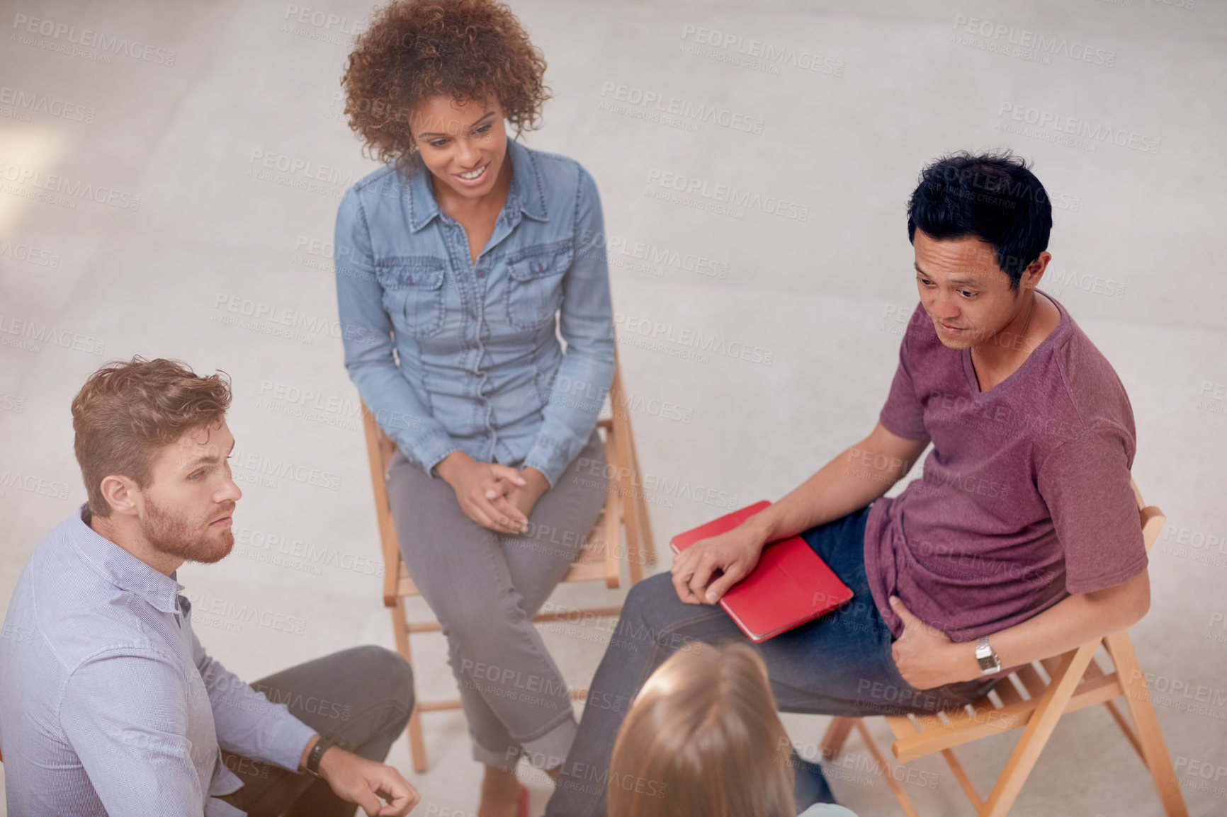 Buy stock photo High angle shot of a group of businesspeople talking together while sitting in a circle in an office