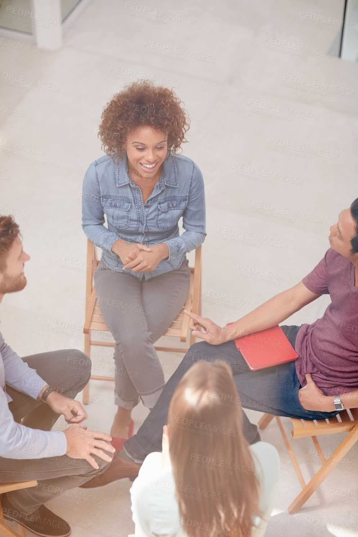 Buy stock photo High angle shot of a group of businesspeople talking together while sitting in a circle in an office