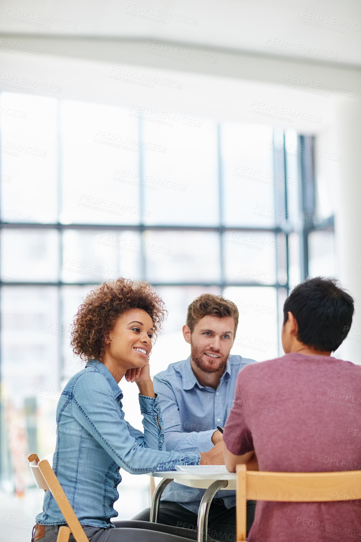 Buy stock photo Shot of a group of businesspeople talking together around a table in an office