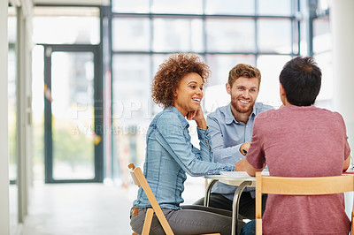 Buy stock photo Shot of a group of businesspeople talking together around a table in an office