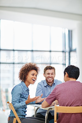 Buy stock photo Shot of a group of businesspeople talking together around a table in an office
