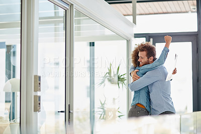 Buy stock photo Cropped shot of two colleagues hugging each other in celebration