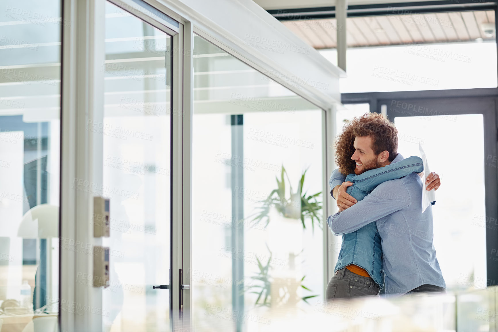 Buy stock photo Cropped shot of two colleagues hugging each other in celebration