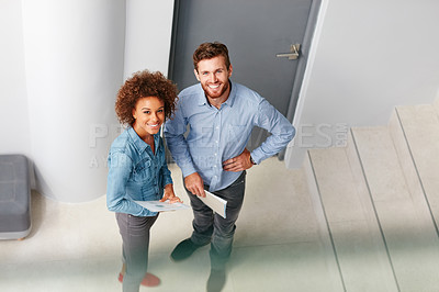 Buy stock photo Shot of two colleagues standing together in an office