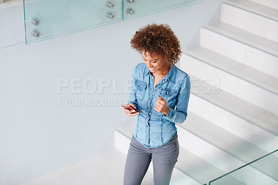 Buy stock photo Cropped shot of a young businesswoman texting on a cellphone in an office
