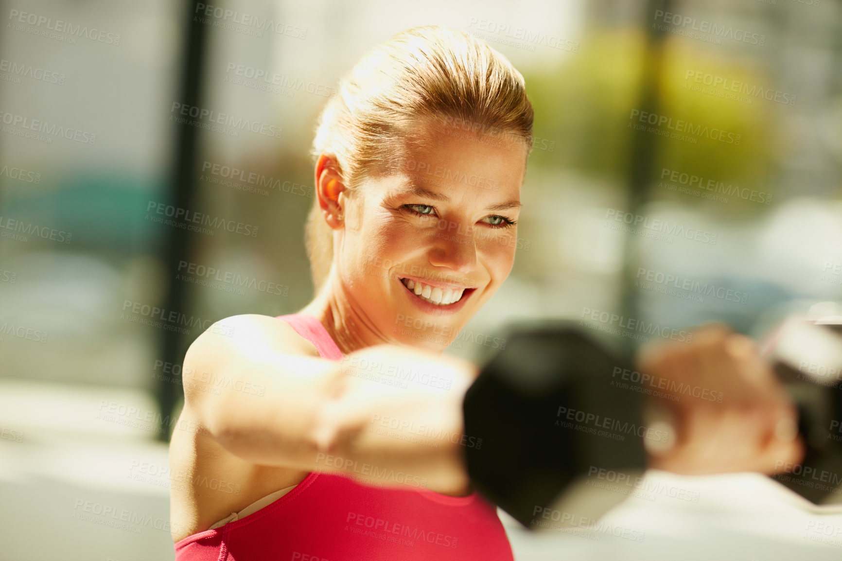 Buy stock photo Cropped shot of an attractive young woman working out with dumbbells