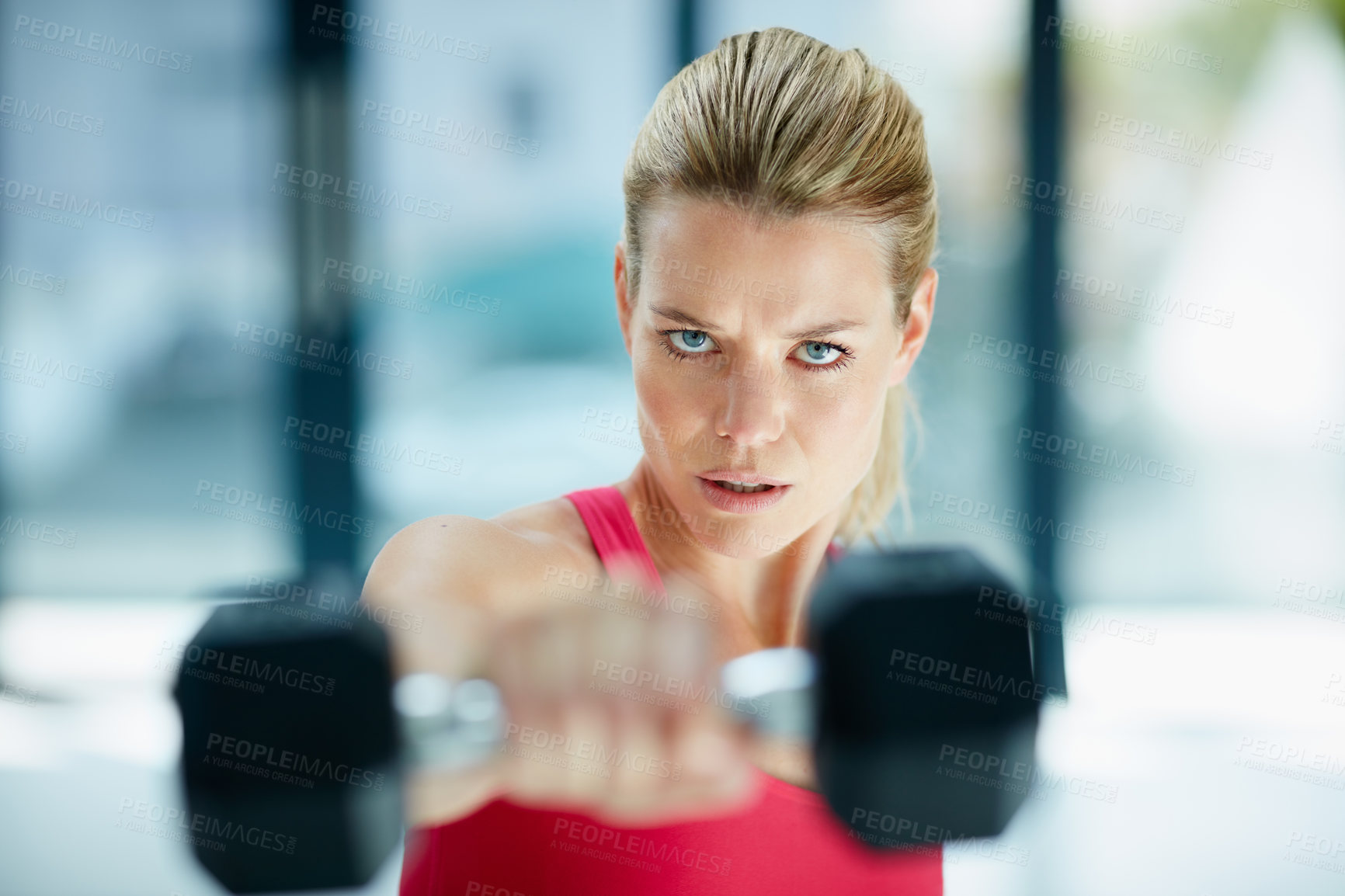 Buy stock photo Cropped portrait of an attractive young woman working out with dumbbells