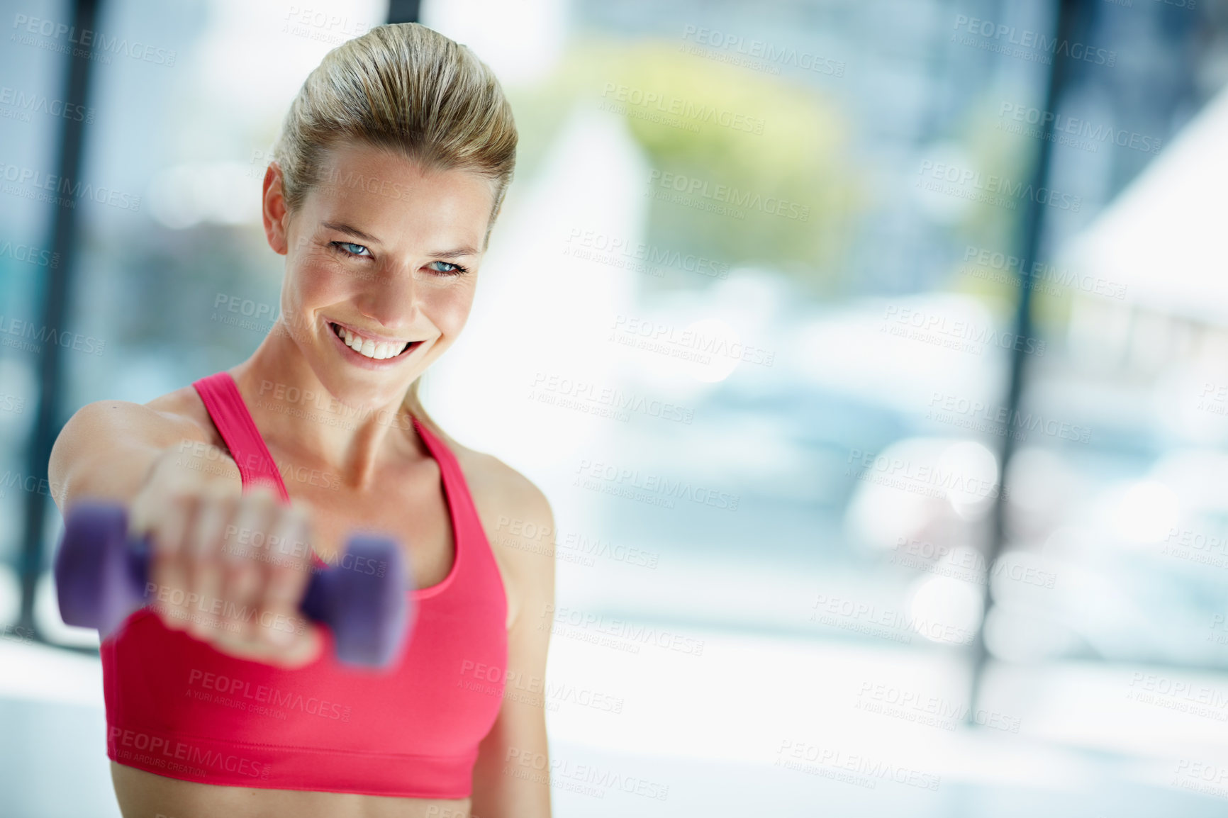 Buy stock photo Cropped shot of an attractive young woman working out with dumbbells