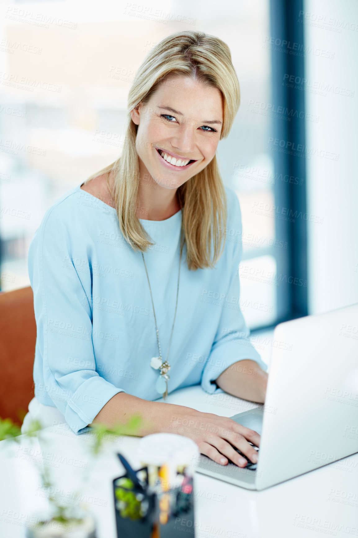 Buy stock photo Portrait of a young businesswoman working on a laptop in an office