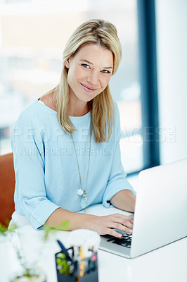 Buy stock photo Portrait of a young businesswoman working on a laptop in an office