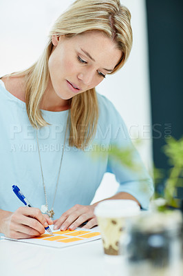 Buy stock photo Cropped shot of a young businesswoman writing notes in an office