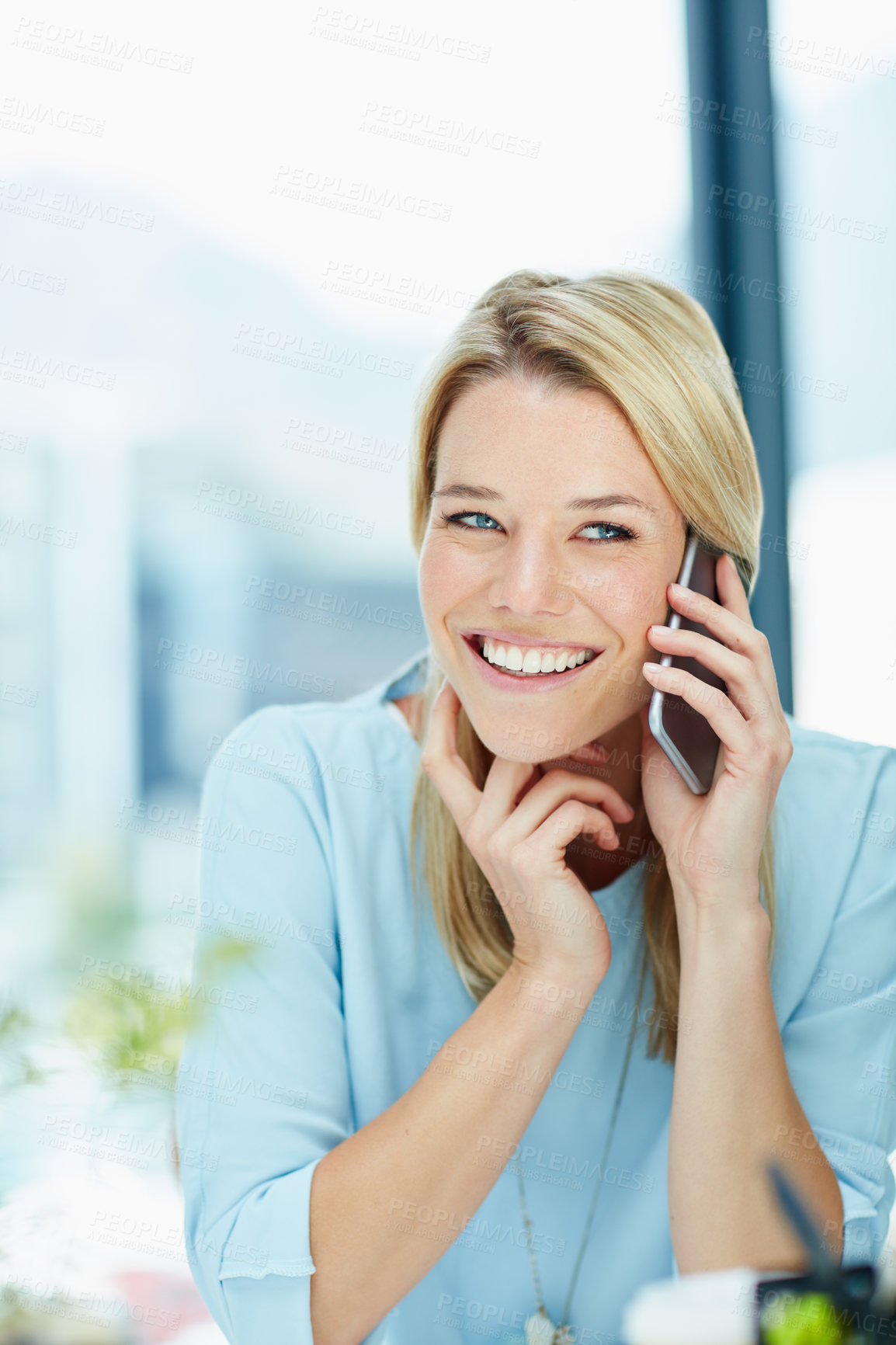 Buy stock photo Cropped shot of a young businesswoman talking on a cellphone in an office