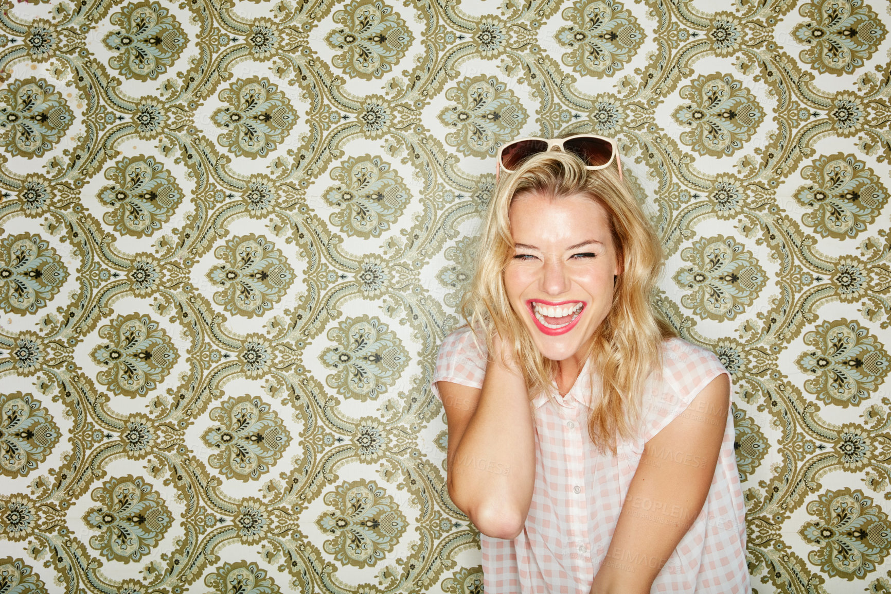 Buy stock photo Shot of a young woman posing against a wallpaper background