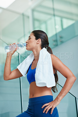 Buy stock photo Shot of a fit young woman drinking water during her workout