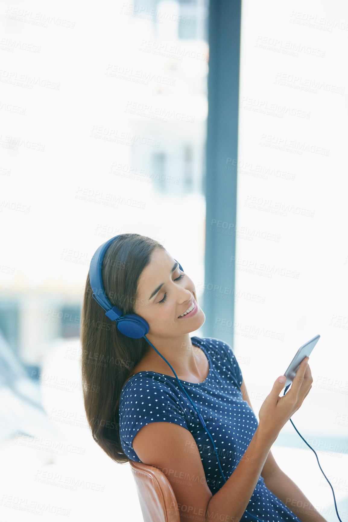 Buy stock photo Shot of an attractive young woman listening to music