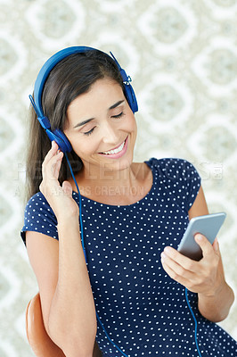 Buy stock photo Shot of an attractive young woman listening to music