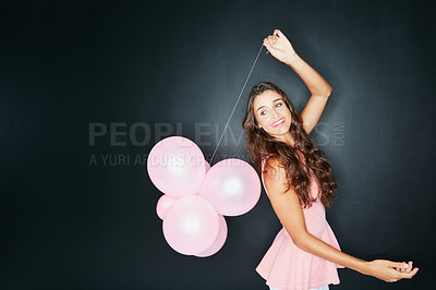 Buy stock photo Studio shot of an attractive young woman holding balloons against a dark background