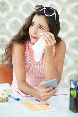 Buy stock photo Cropped shot of a young woman reading an emotional text message
