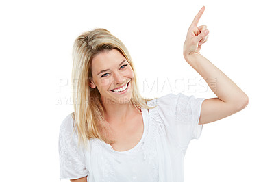 Buy stock photo Studio portrait of an attractive young woman pointing at copyspace against a white background