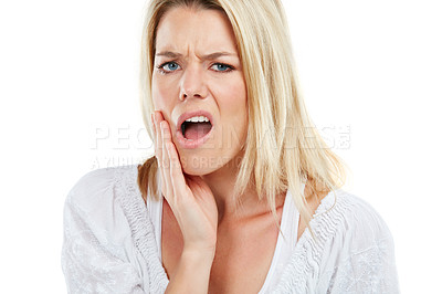 Buy stock photo Studio portrait of a young woman experiencing toothache against a white background