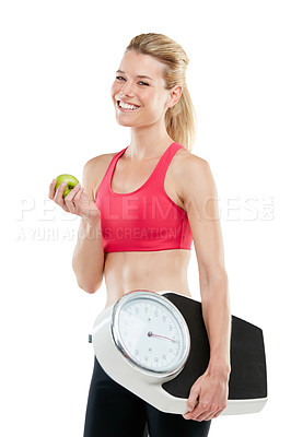 Buy stock photo Studio shot of a woman holding an apple and a scale