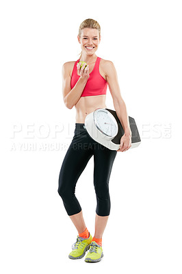 Buy stock photo Studio shot of a woman holding an apple and a scale