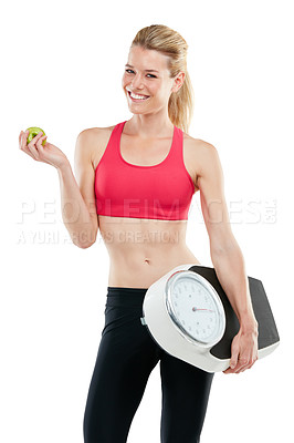 Buy stock photo Studio shot of a woman holding an apple and a scale