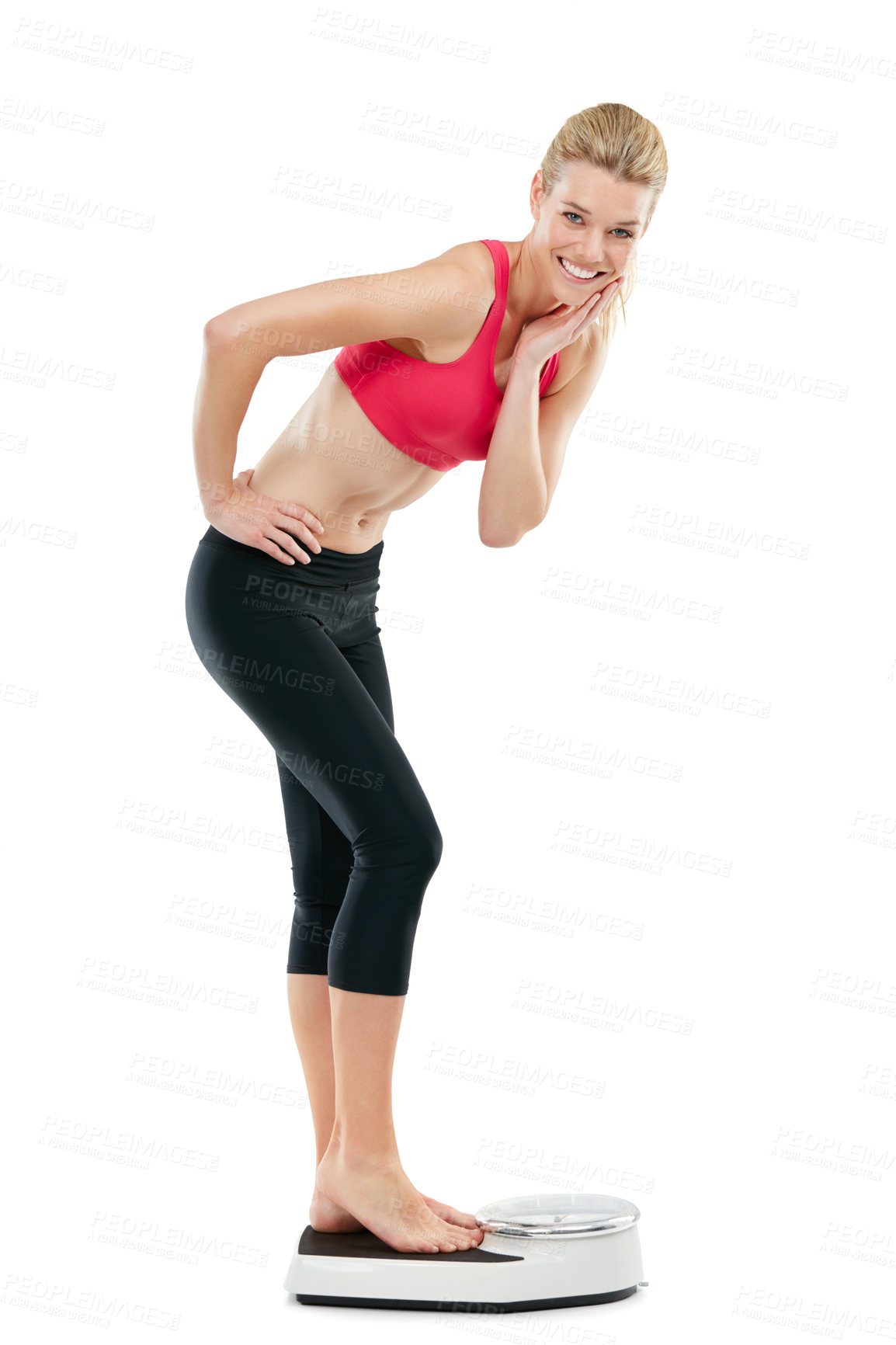 Buy stock photo Studio shot of a young woman weighing herself on a scale