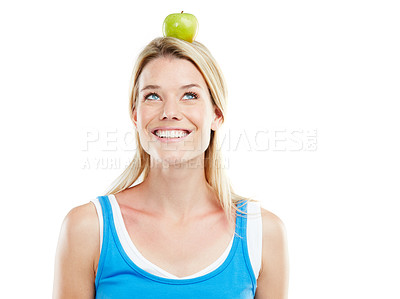 Buy stock photo Studio shot of an attractive young woman with an apple on her head