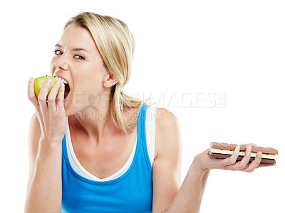 Buy stock photo Studio shot of a woman deciding between healthy and unhealthy foods