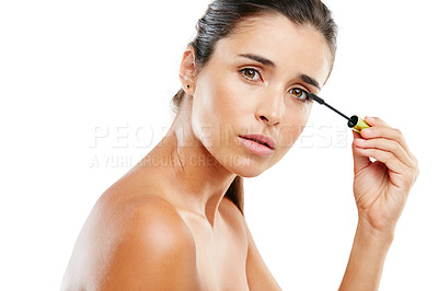 Buy stock photo Studio portrait of a beautiful young woman applying mascara against a white background