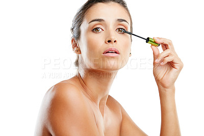 Buy stock photo Studio portrait of a beautiful young woman applying mascara against a white background