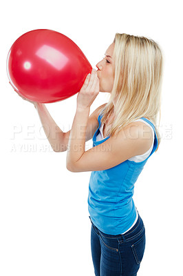 Buy stock photo Shot of a young woman blowing up a balloon against a white background