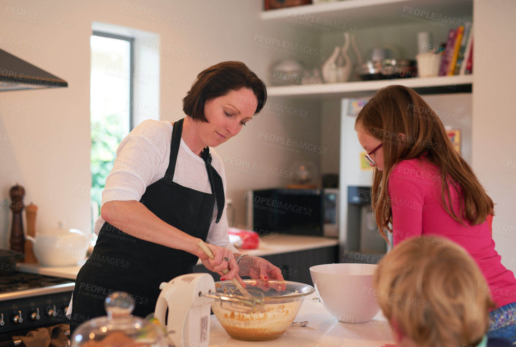 Buy stock photo Mother, children and baking in kitchen in home, family and bonding together with mixing machine on counter table. Mom, apron and daughter with son watching, waiting for cookie dough in apartment