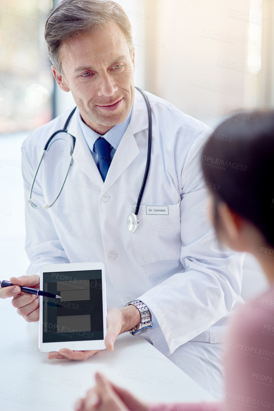 Buy stock photo Cropped shot of a male doctor talking to a patient in his office