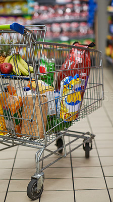 Buy stock photo Grocery, shopping cart and banana in supermarket for ingredients, food and products for nutrition. No people, retail and inside store with fruit for shopping, vegetables and healthy diet in city