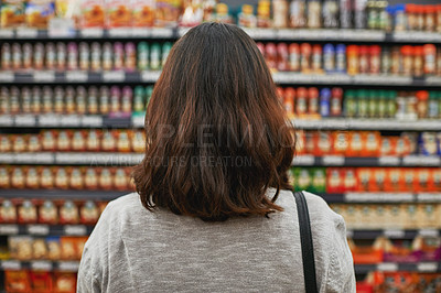 Buy stock photo Rear view shot of a woman browsing for items in a grocery store