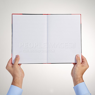 Buy stock photo Cropped shot of an unidentifiable man holding up a blank notebook in studio