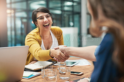 Buy stock photo Shot of a creative businesswoman shaking her new coworker's hand in the office