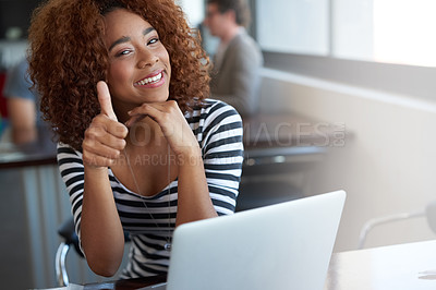 Buy stock photo Portrait of a young woman winking and giving the thumbs up while sitting in an office