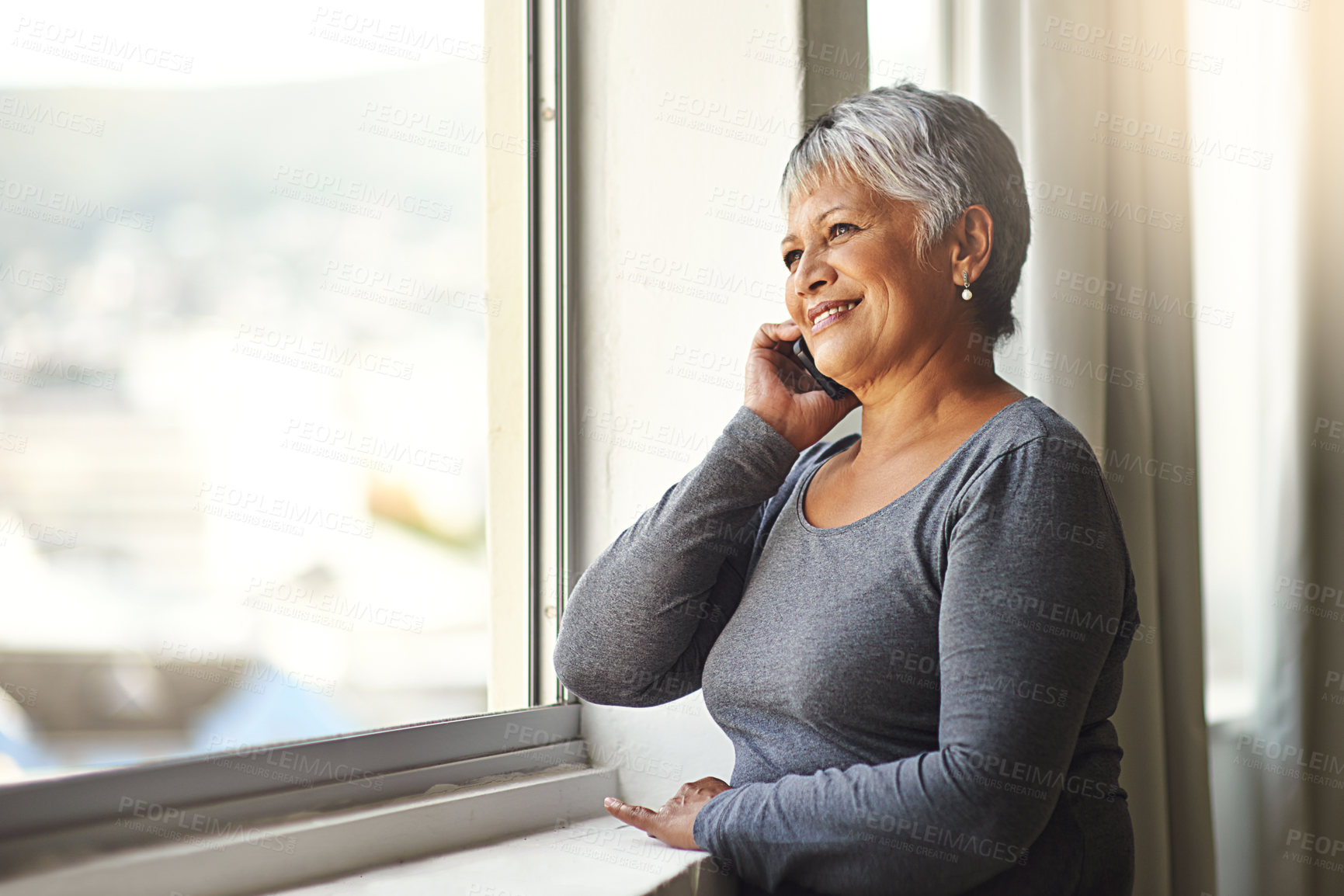 Buy stock photo Shot of a mature woman using her cellphone at home