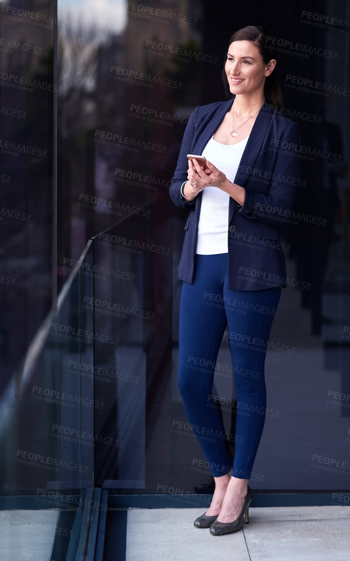 Buy stock photo Businesswoman, smile and smartphone on office balcony for networking, communication or schedule in city. Female person, thinking and assistant by window for update, social media or phone call in town