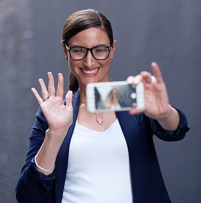 Buy stock photo Shot of a happy businesswoman taking a fun selfie with her smartphone