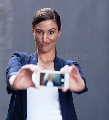 Buy stock photo Corporate woman, selfie and cellphone by dark background for happiness, social media and funny face. Confident female person, technology and glasses with comic emoji for networking and connection