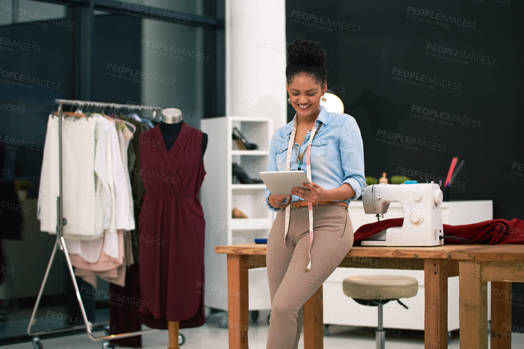 Buy stock photo Shot of a fashion designer working on her digital tablet