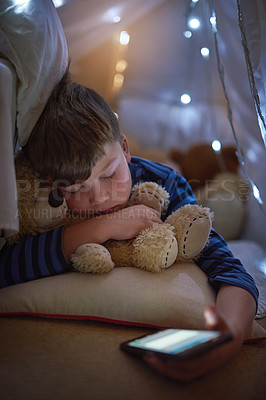 Buy stock photo Cropped shot of a young boy sleeping with a cellphone in hand under a blanket fort at home